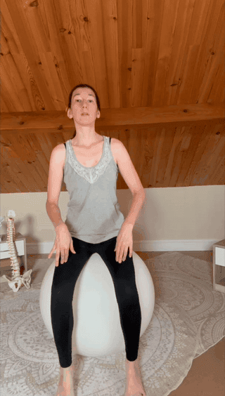 Une praticienne assise sur un ballon de gymnastique réalise un mouvement doux du bassin.